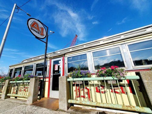 A1 Diner exterior with colorful flowers, a sign, and a clear blue sky in the background.