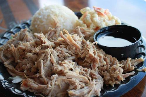 A plate of shredded meat, rice, macaroni salad, and a small cup of sauce.