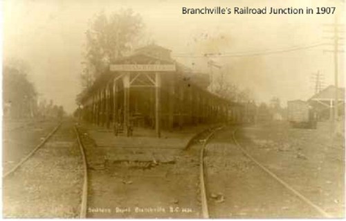 Historic photo of Branchville's Railroad Junction in 1907, featuring tracks and a station building.