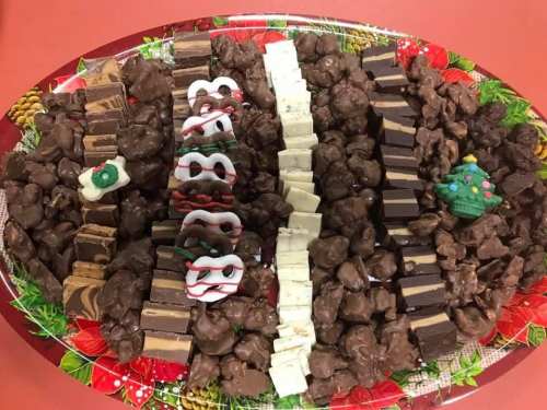 A festive platter of assorted chocolates, including clusters, fudge, and holiday-themed decorations.
