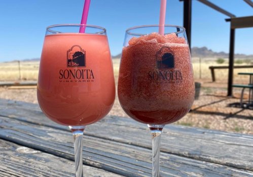 Two drinks from Sonoita Vineyard: a pink cocktail in a glass and a frozen slush in a cup, set against a sunny outdoor backdrop.