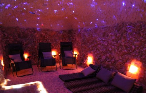 A tranquil salt room with reclining chairs, soft lighting, and a calming atmosphere for relaxation.