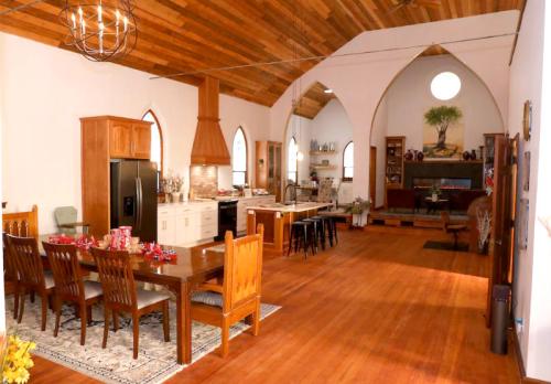 Spacious kitchen and dining area with wooden accents, large windows, and a cozy living space in a unique architectural style.