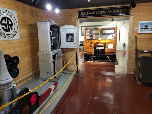 Interior of a railway museum featuring vintage equipment, signals, and a display of an orange train vehicle.