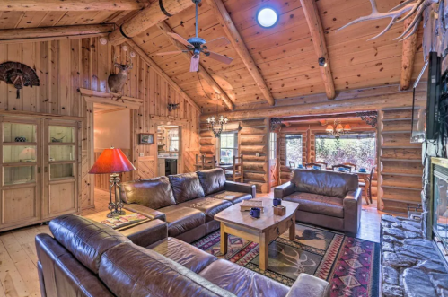 Cozy log cabin interior with leather sofas, wooden beams, and rustic decor, featuring a warm, inviting atmosphere.