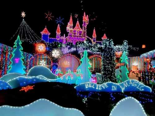 A colorful holiday display featuring a castle, trees, and snowmen, all illuminated with vibrant lights.