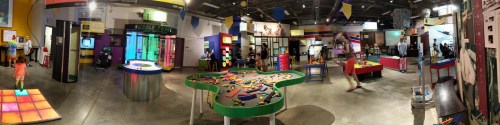 A colorful children's museum exhibit featuring interactive displays, play areas, and various educational activities.