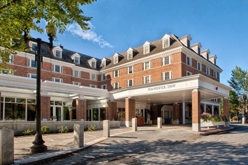 Exterior view of the Hanover Inn, featuring brick architecture and a welcoming entrance under a clear blue sky.