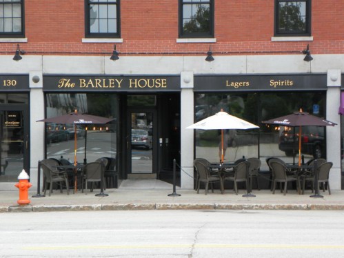 Exterior of The Barley House with outdoor seating, umbrellas, and a fire hydrant in front.