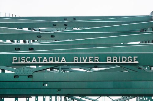 Sign on the Piscataqua River Bridge, featuring green metal beams and the bridge's name in white letters.