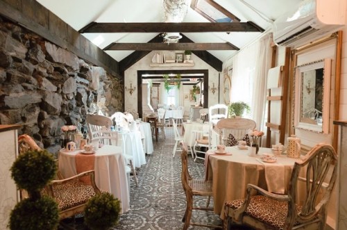 Cozy dining area with stone walls, elegant tables, and soft lighting, creating a warm and inviting atmosphere.
