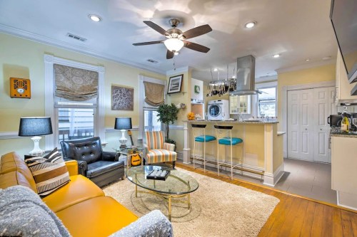 Cozy living area with a mix of modern and classic decor, featuring a kitchen bar, comfortable seating, and bright colors.