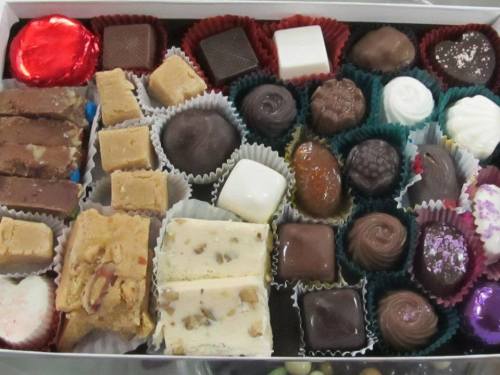 A variety of chocolates and confections arranged in a box, featuring different shapes and colors.