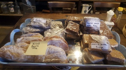 A tray of assorted fudge and treats, including fried apple pie, chocolate peanut butter fudge, and peanut butter fudge.