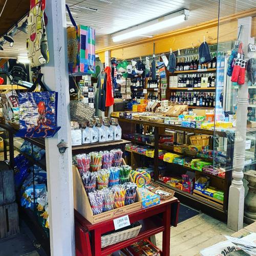A cozy shop filled with snacks, drinks, and various goods, featuring colorful displays and wooden shelves.