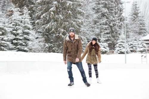 A couple ice skating together in a snowy landscape, surrounded by evergreen trees.