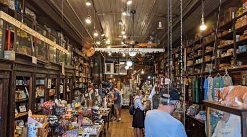 A cozy, vintage store filled with shelves of books, gifts, and various items, with customers browsing around.