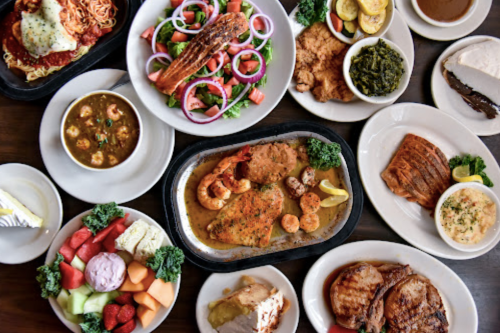 A variety of delicious dishes including pasta, seafood, salads, and desserts arranged on a table.