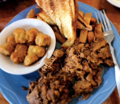 A plate with pulled pork, toast, fries, and a side of golden-brown fried okra.