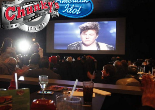 A crowd watches a performance on a large screen at Chunky's Pub during an American Idol event.