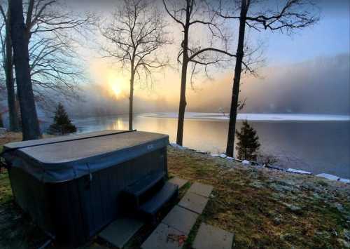 A hot tub by a misty lake at sunrise, surrounded by trees and a serene, foggy landscape.