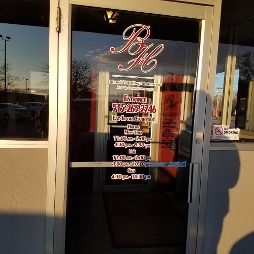 Entrance door of Bianchi's Pizzeria with hours and contact information displayed on the glass.