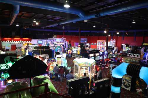 A vibrant arcade filled with various games, colorful lights, and people enjoying their time.