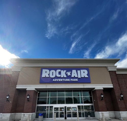Exterior of Rock 'n Air Adventure Park with a blue sky and clouds in the background.