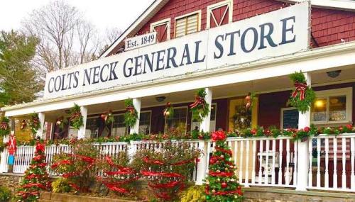 A festive general store decorated with holiday wreaths and garlands, featuring a sign that reads "Colts Neck General Store."