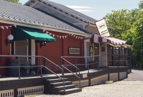 A charming building with a red exterior, green awnings, and a sign reading "Depot Grille" on a sunny day.