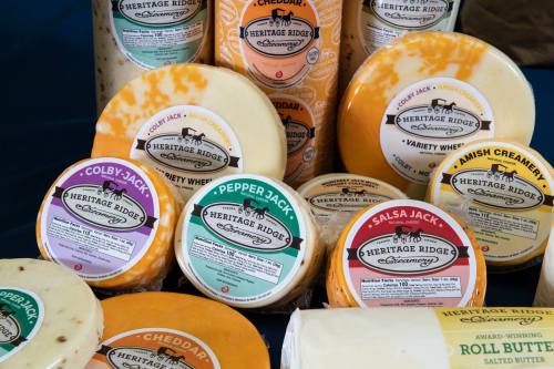 A variety of cheese wheels and blocks from Heritage Ridge, featuring different flavors and labels.