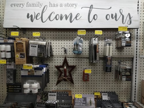A store display featuring home decor items, including candles and wall art, with a sign that reads "Welcome to Ours."