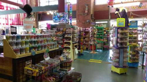 A colorful candy store interior filled with shelves of sweets, jars, and vibrant decorations.