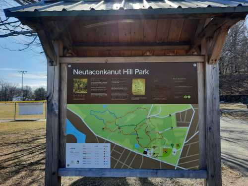 Signboard at Neutaconkanut Hill Park displaying a map and information about trails and park features.