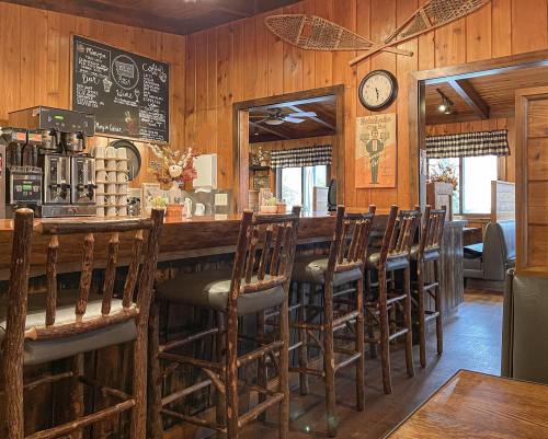 Cozy wooden café interior with a bar, high stools, chalkboard menu, and rustic decor. Warm, inviting atmosphere.