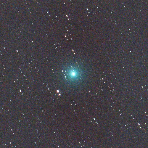 A bright green comet surrounded by stars against a dark, starry sky.