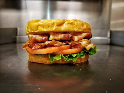 A delicious sandwich with layers of bacon, lettuce, and tomato, served on a toasted bun.