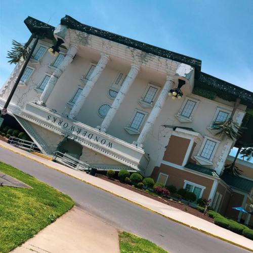 A tilted building with a whimsical design, featuring large columns and a sign that reads "WonderWorks."