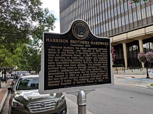 Historic marker for Harrison Brothers Hardware, established in 1879, detailing its history and significance in Alabama.