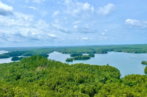A scenic view of lush green islands and lakes under a partly cloudy sky.