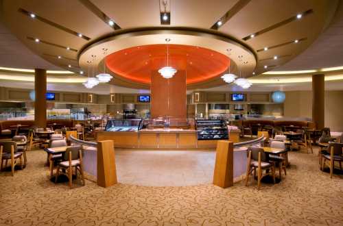 Modern café interior with circular ceiling, elegant lighting, and cozy seating arrangements.