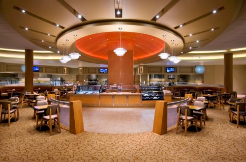 Modern café interior with circular ceiling, elegant lighting, and cozy seating arrangements.
