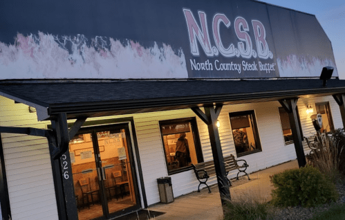 Exterior of North Country Steak Buffet restaurant, featuring a large sign and welcoming entrance at dusk.