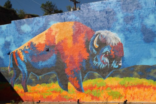 Colorful mural of a bison on a blue and green background, showcasing vibrant hues and artistic details.
