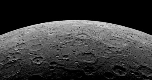 Close-up view of a cratered lunar surface against a black background, showcasing detailed textures and shadows.