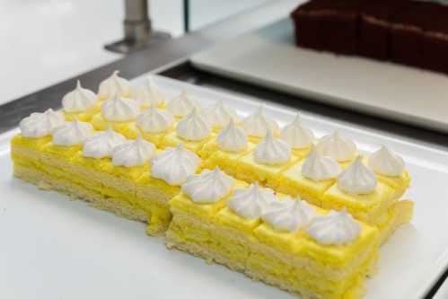 A rectangular yellow cake topped with white meringue peaks, displayed on a white plate.