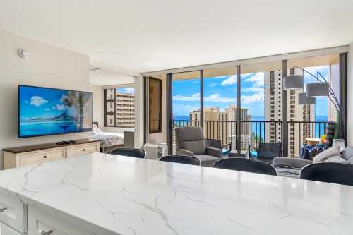 Bright living room with ocean view, modern decor, large windows, and a marble countertop.