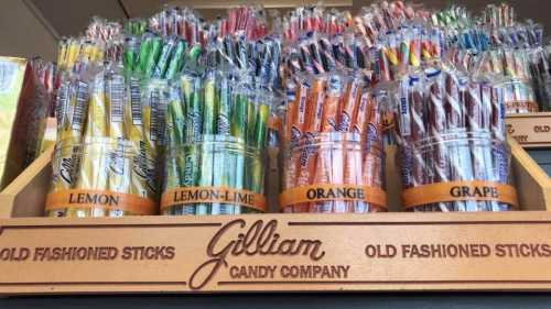 A display of colorful candy sticks in jars labeled lemon, lemon-lime, orange, and grape at Gilliam Candy Company.