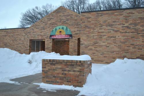 Exterior of a brick building with a sign reading "Meskwaki Cultural Center and Museum," surrounded by snow.