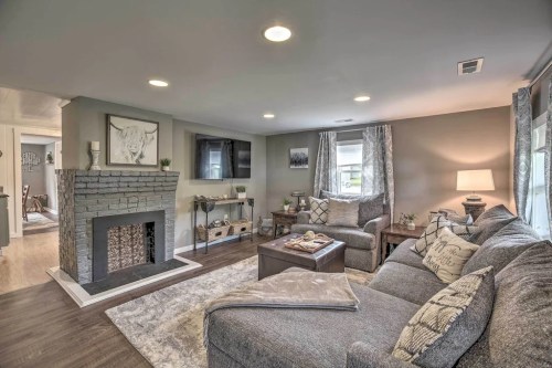 Cozy living room with a gray sofa, fireplace, TV, and decorative accents, featuring warm lighting and a soft rug.